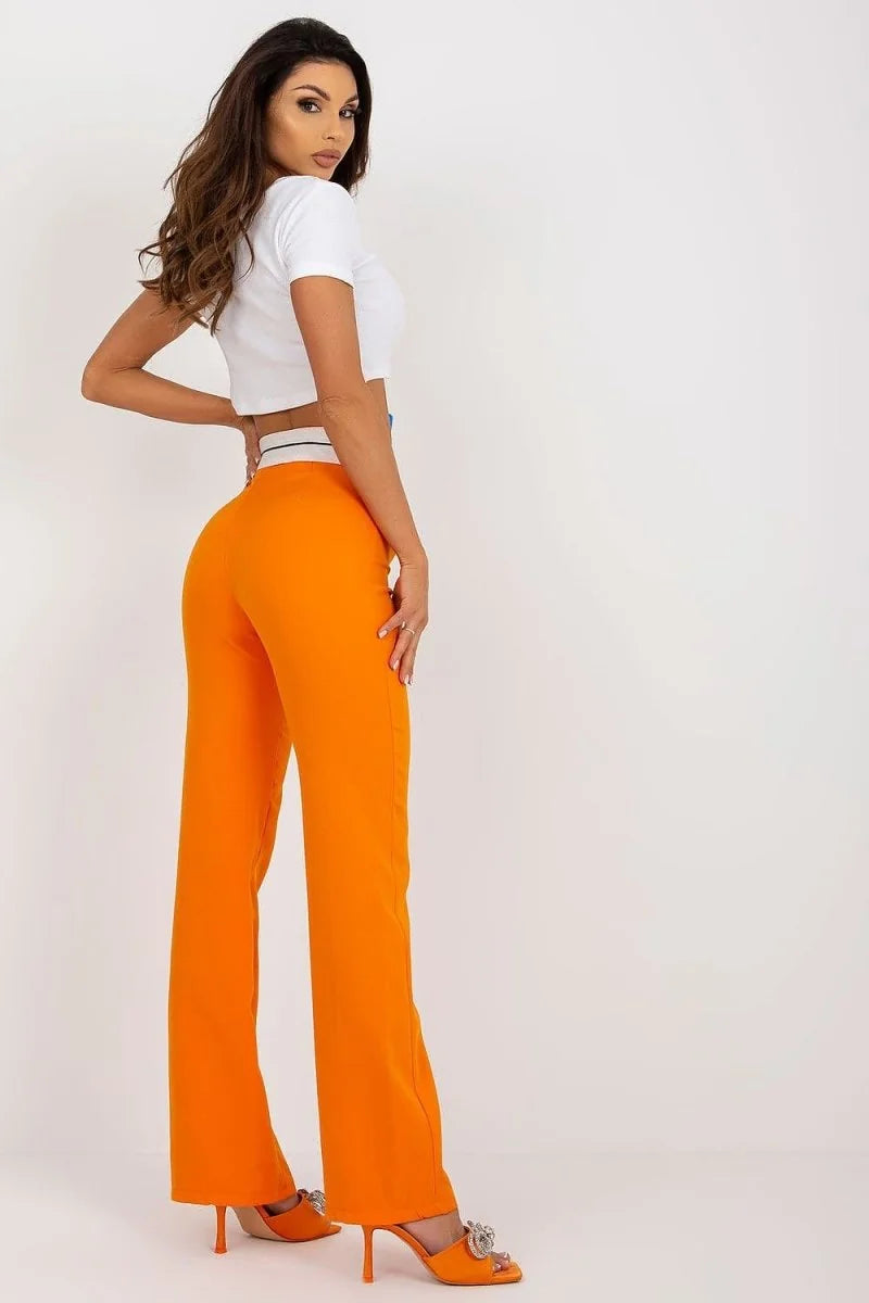 Orange wide-leg pants with a high waist and embellished heels on a model.