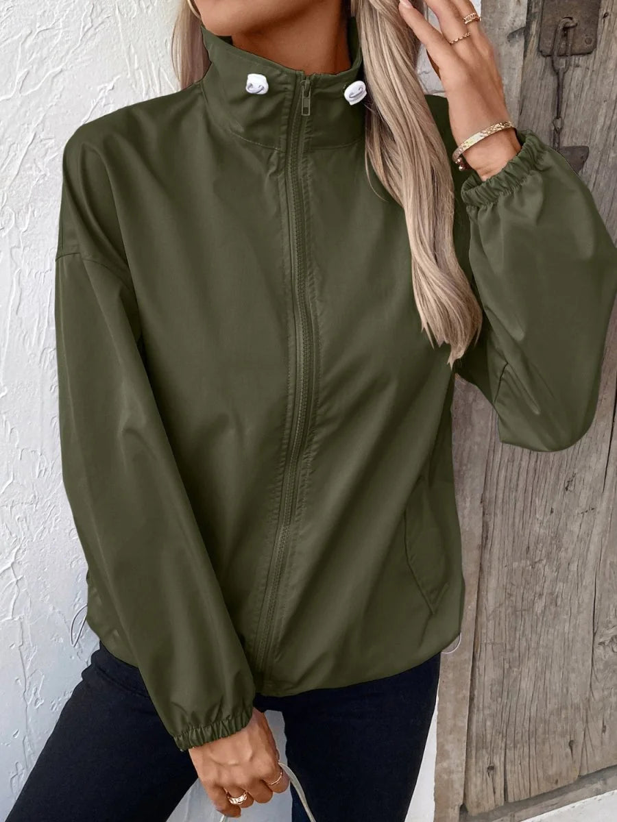 Olive green polyester jacket with a full zip, stand-up collar, and elastic cuffs on model.
