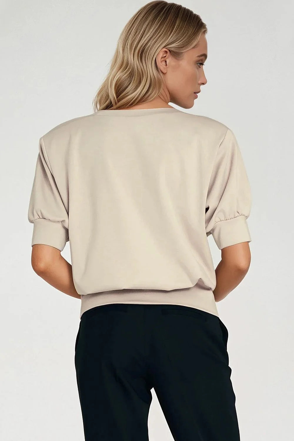Oversized beige sweatshirt with puff sleeves and black pants, back view.