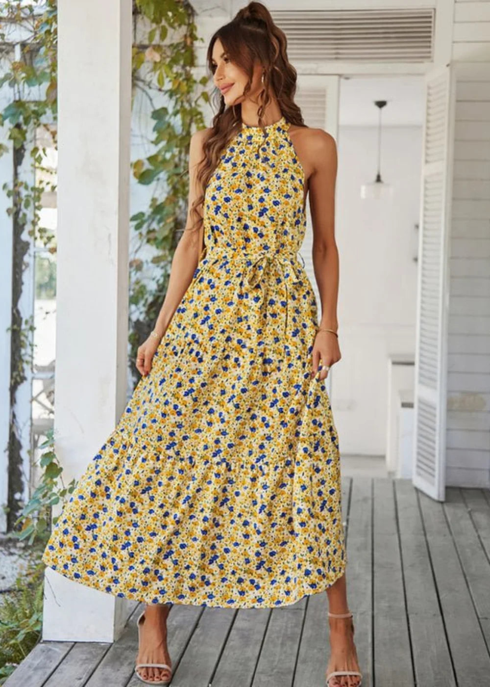 Yellow floral print halter maxi dress with a tie waist, worn by a model.