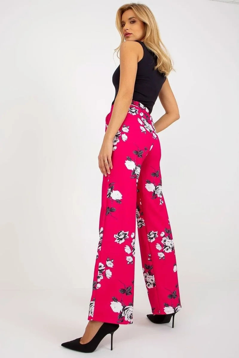 Bright pink wide-leg pants with a white and black floral print, on a model.