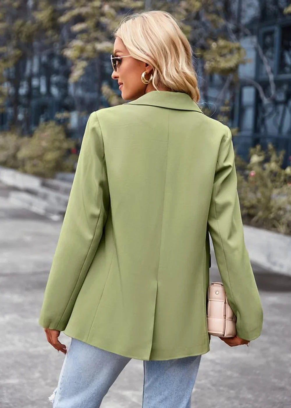 Woman in a light green blazer and jeans, showing the back of the blazer.