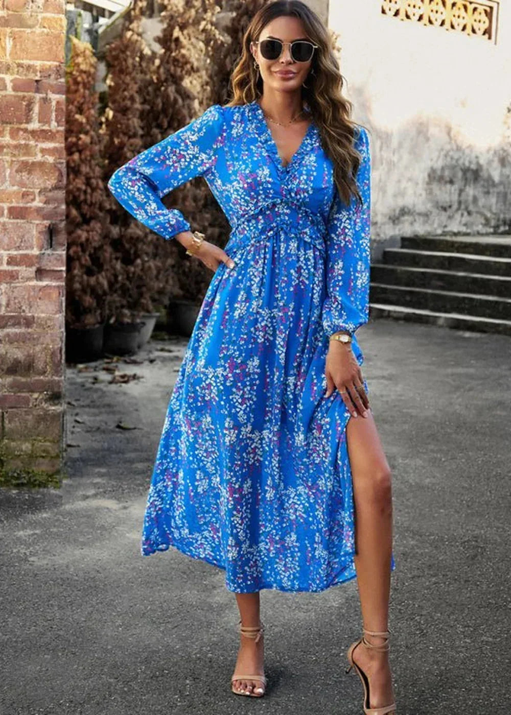Blue floral print midi dress with V-neck, smocked waist, and thigh-high slit on model.