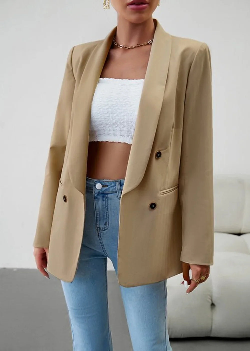 Tan double-breasted blazer with a textured white bandeau top and light wash jeans on a model.
