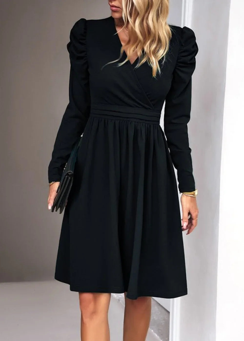 Black long-sleeve dress with V-neck and cinched waist, shown on model.