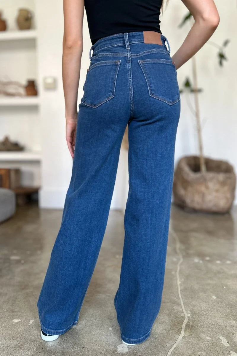 Dark wash denim wide-leg jeans with a high waist, shown from the back on a model.