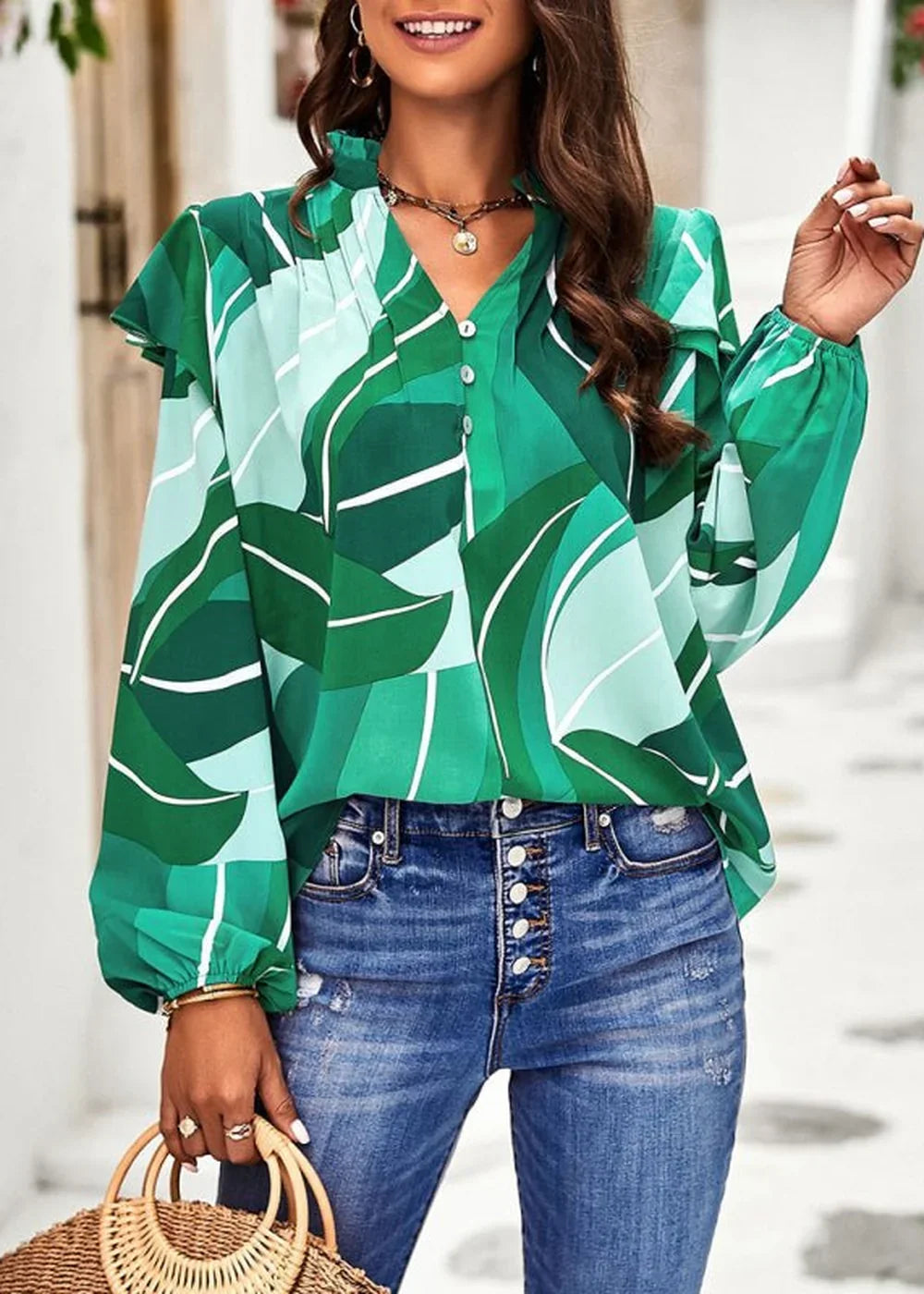 Green and light green abstract leaf print long-sleeve blouse with V-neck and ruffled shoulders.