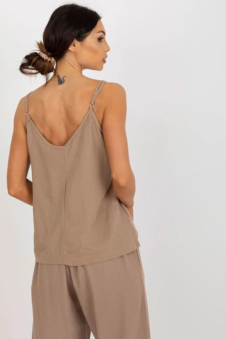 A woman from behind wearing a loose-fitting, taupe camisole with spaghetti straps and matching wide-leg pants.