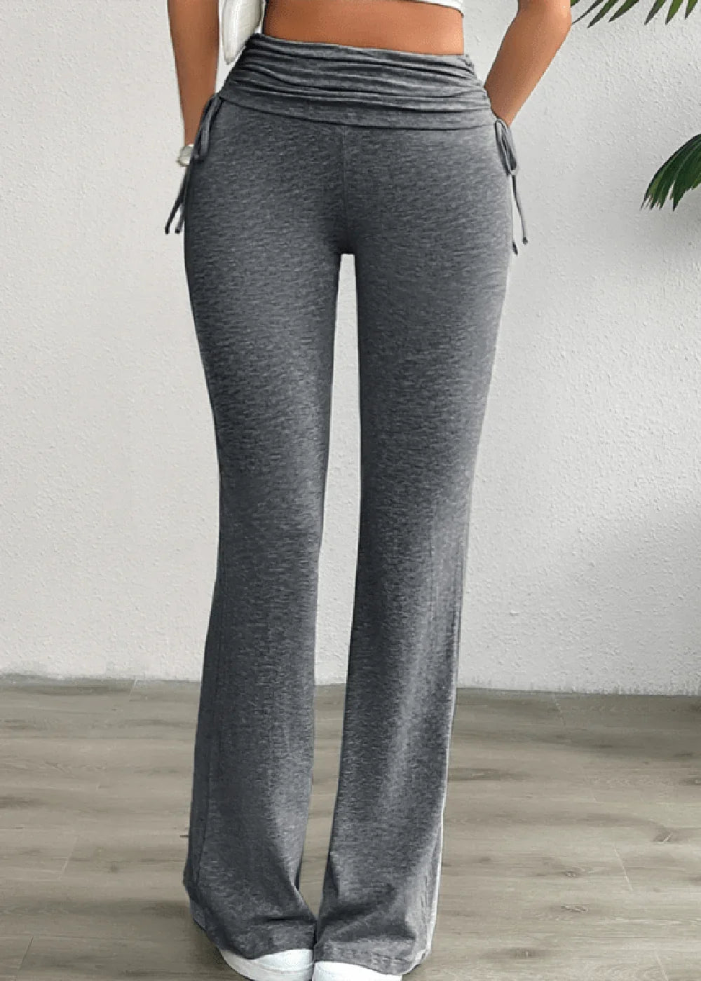 Grey flared pants with ruched drawstring waist and side tie details.