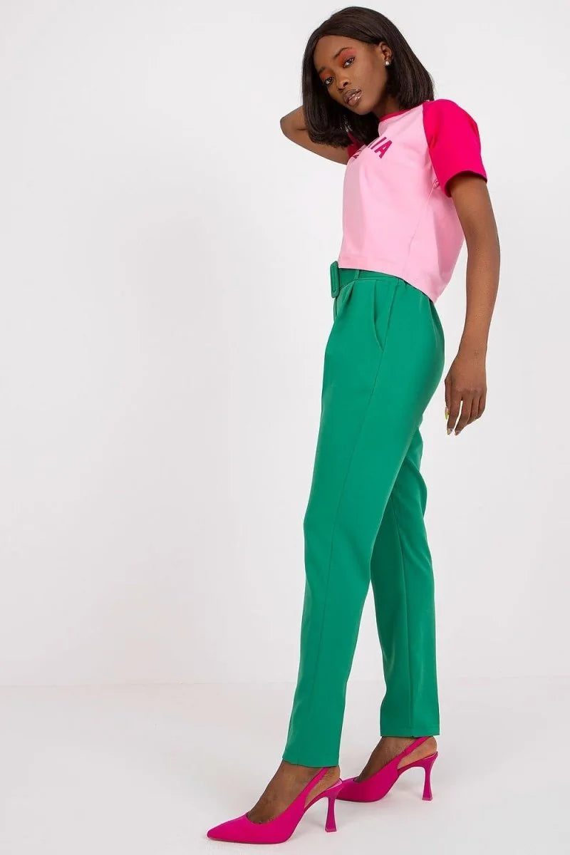 Green high-waisted trousers with a belt and side pockets, on a model.