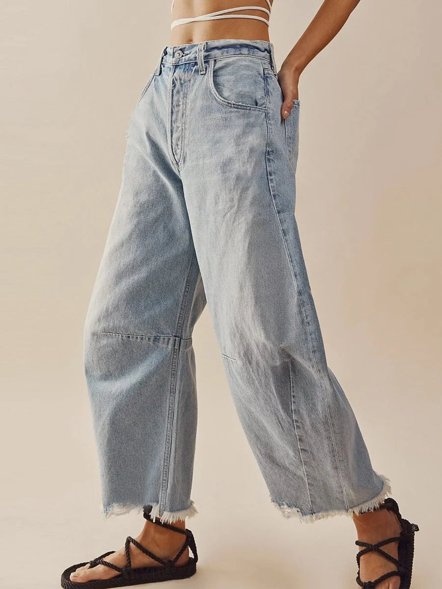 Light wash, high-waisted wide-leg jeans with frayed hems and a relaxed fit.