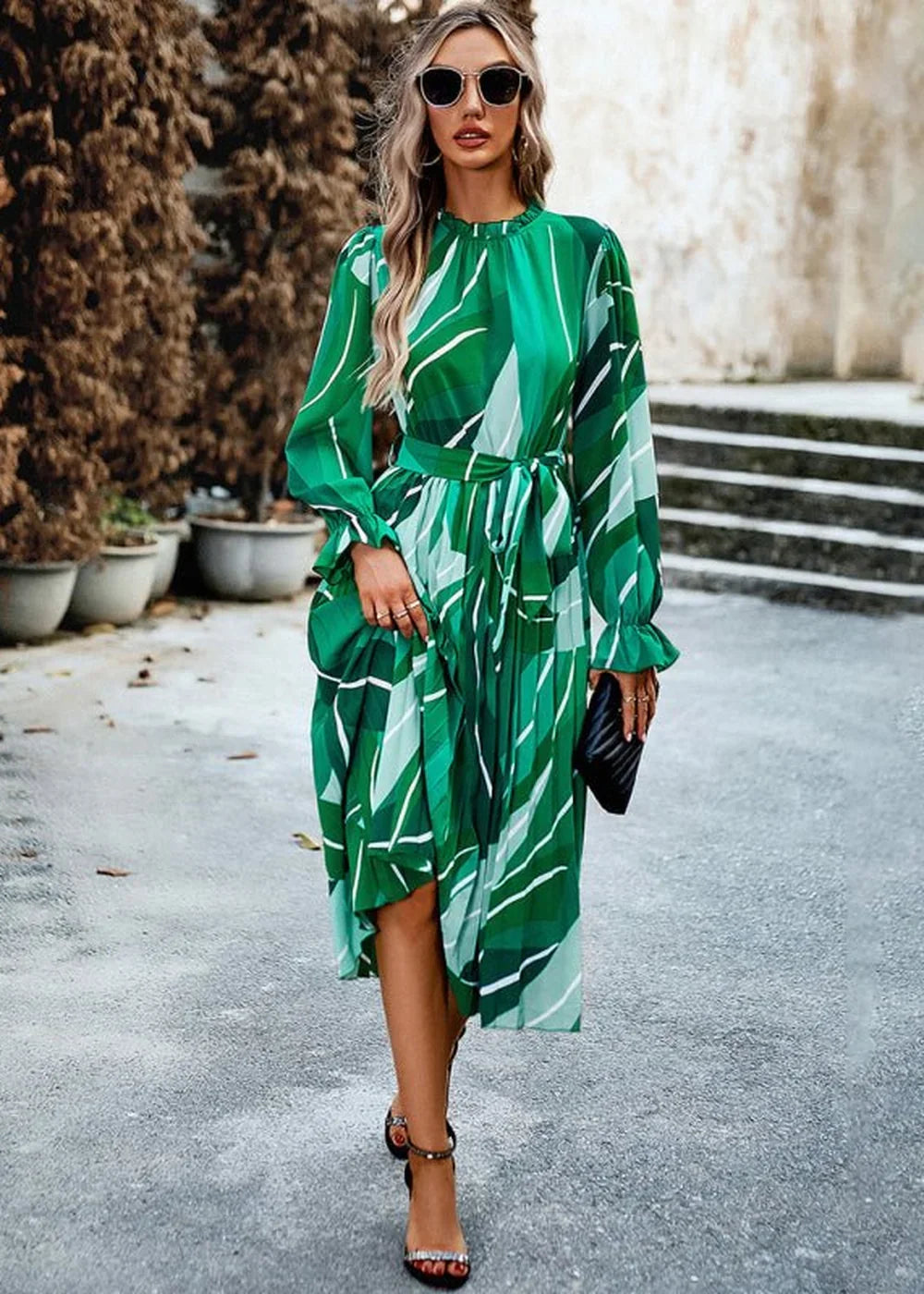 Green and white abstract print midi dress with tie waist and long sleeves on model.