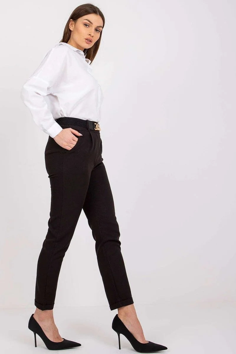 Black high-waisted tapered pants with a gold buckle belt on a model.