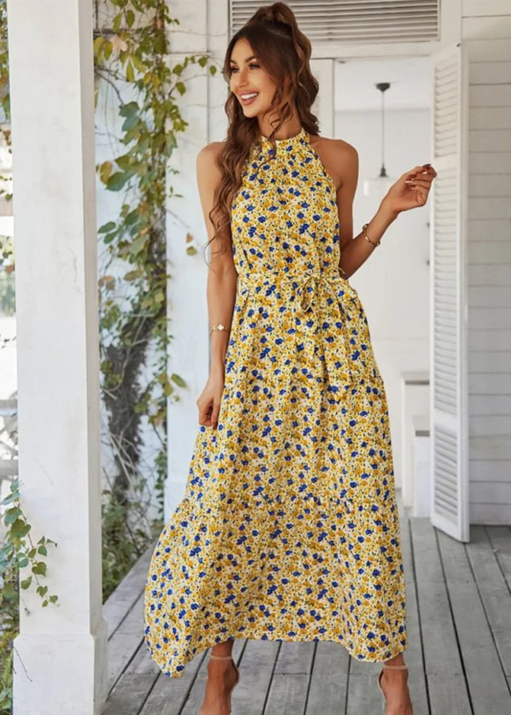 Yellow floral maxi dress with a halter neck and tie waist, on a model.