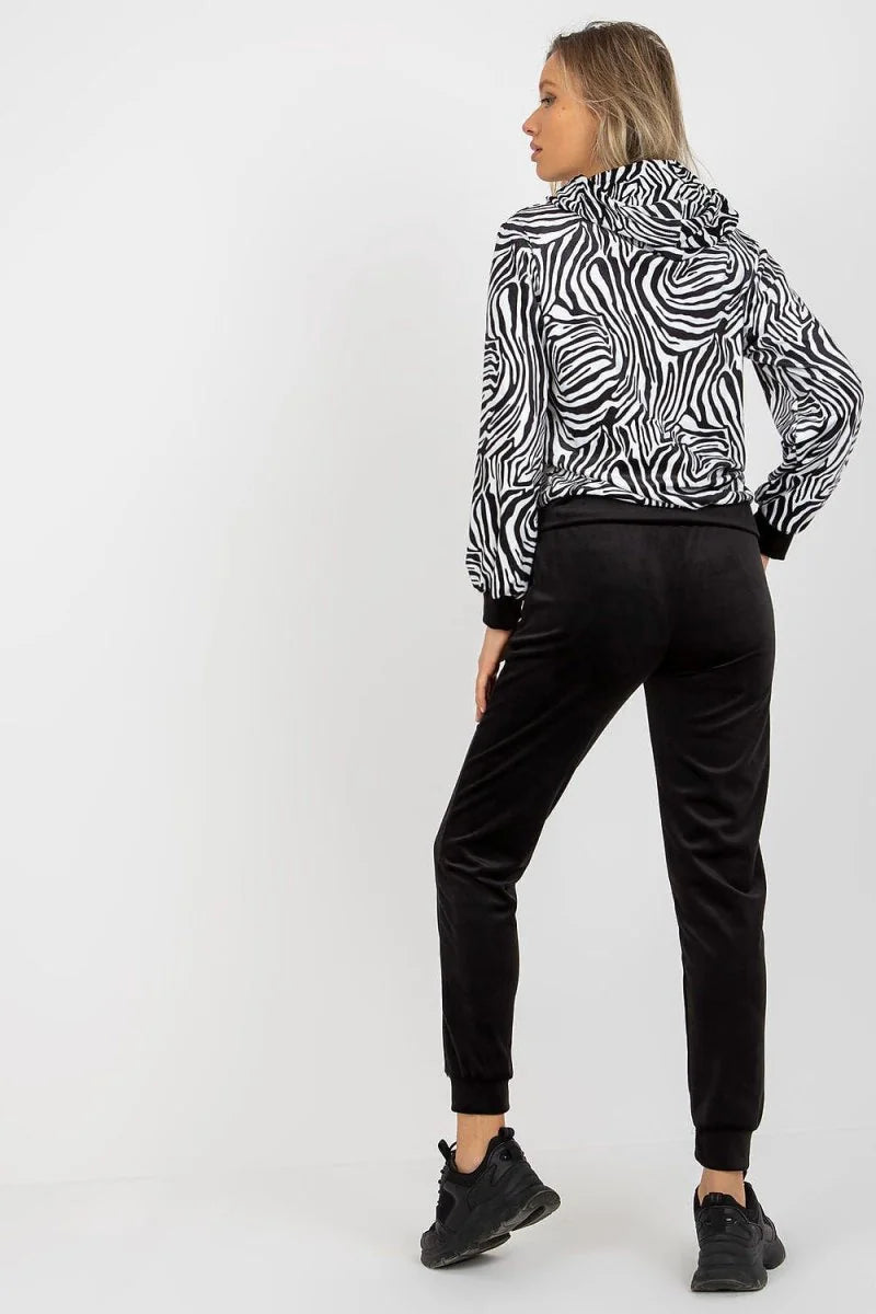 Black velvet joggers with a zebra print hooded jacket on a model.