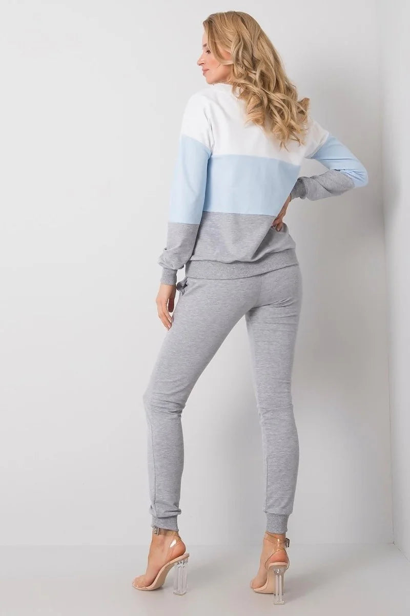 Light grey joggers with elastic cuffs and drawstring waist, on model with clear heels.