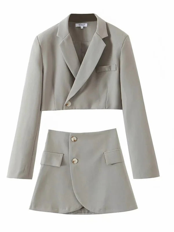 Light gray cropped blazer and wrap skirt with button details and pocket flaps.