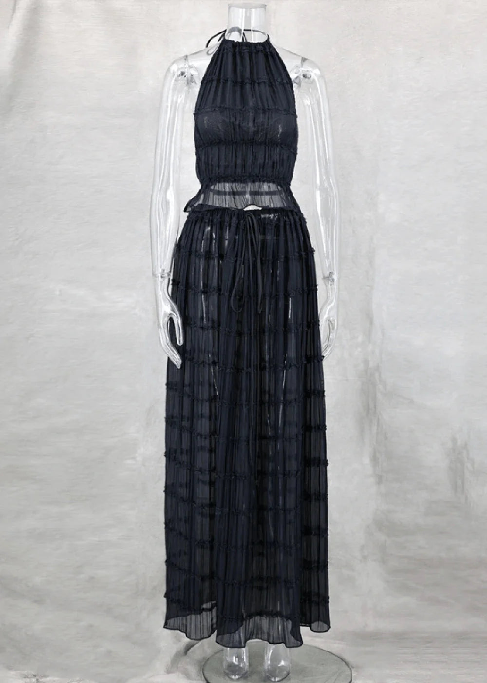 Black sheer maxi skirt with a tiered, ruched design and drawstring waist.