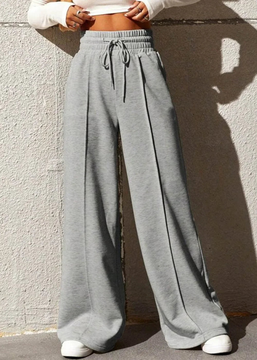 Grey wide-leg sweatpants with drawstring waist and stitched pleats.
