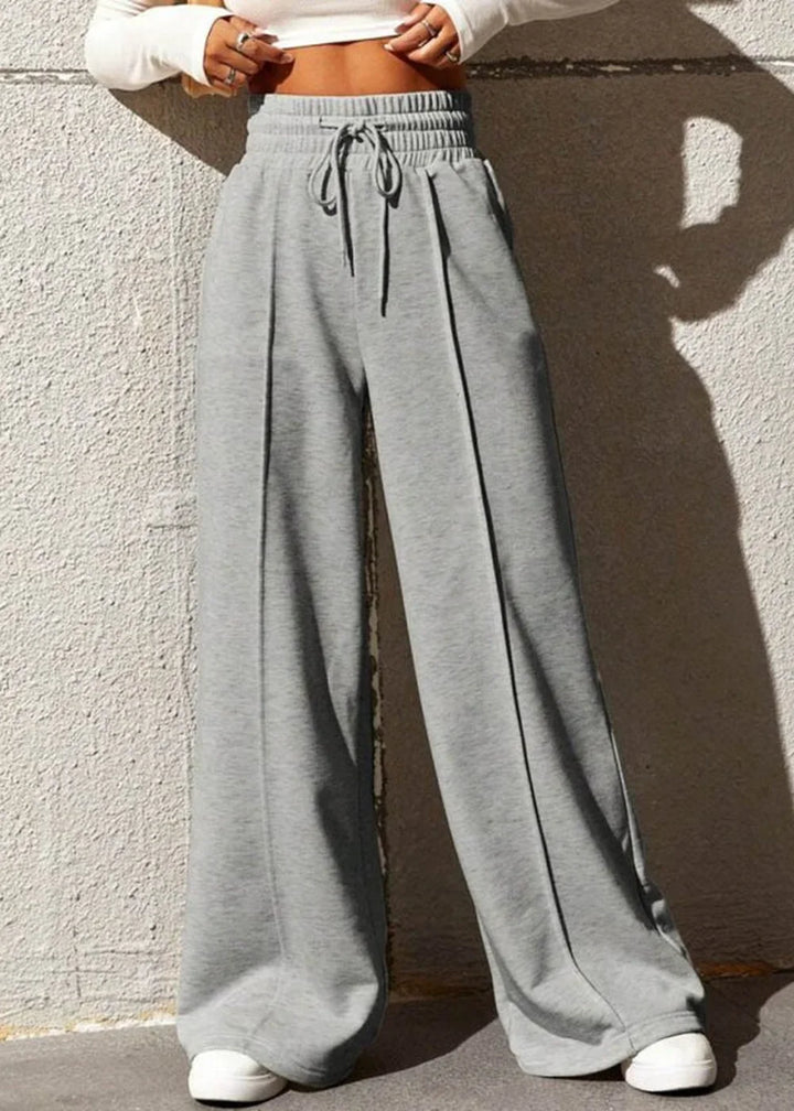 Grey wide-leg sweatpants with drawstring waist and stitched pleats.
