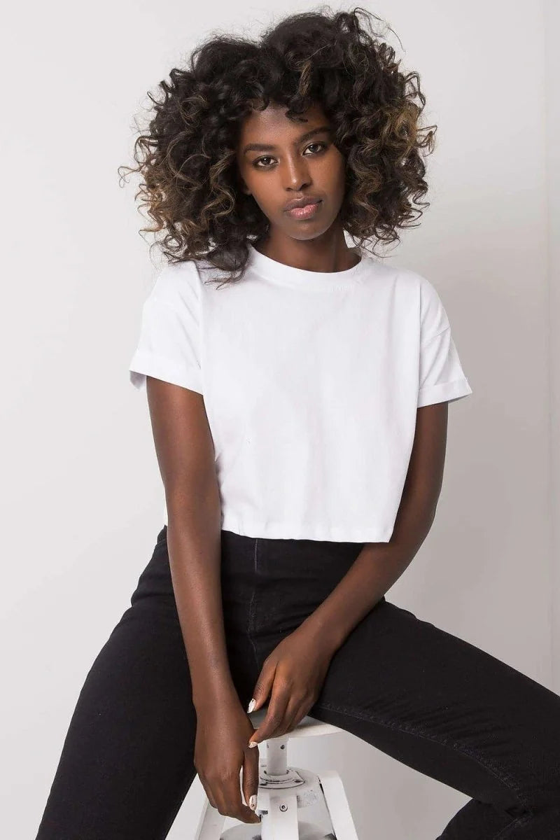 Loose fit white cropped t-shirt on a dark-skinned model with curly hair.