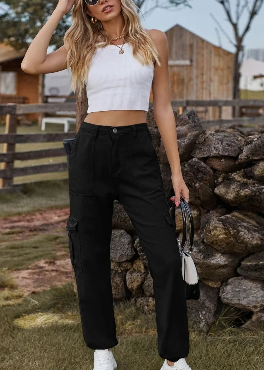 Black cargo pants with a regular fit, featuring pockets on the legs, worn by a model.