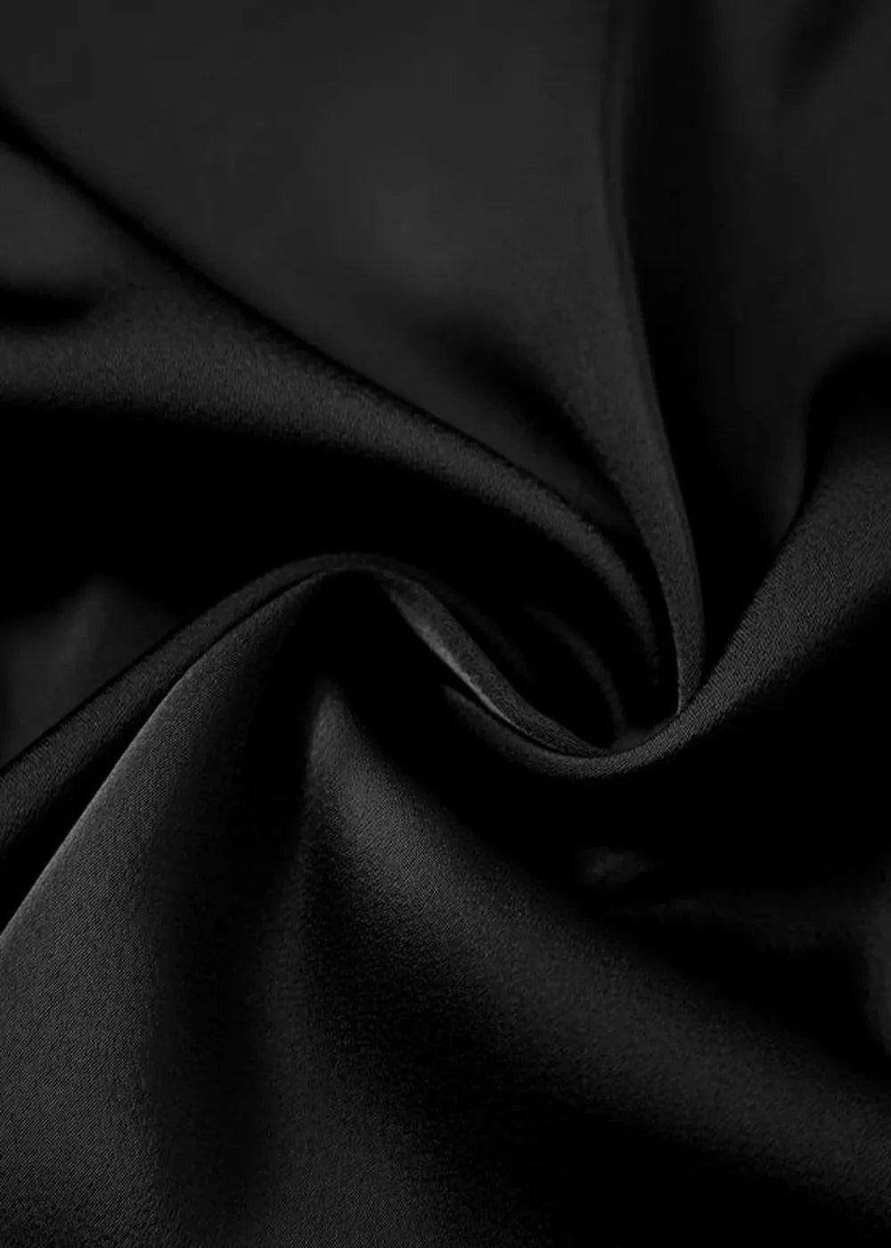 Close-up of black satin fabric with soft folds and a subtle sheen.