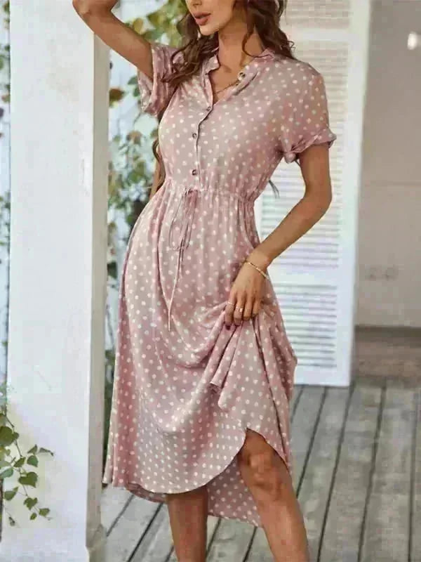 Pink polka dot rayon dress with drawstring waist and button-up shirt collar on a model.