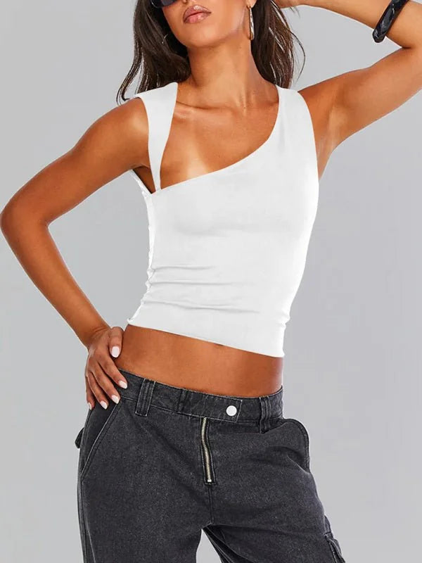 White one-shoulder crop top with a cutout detail, shown on a model wearing dark wash cargo pants.