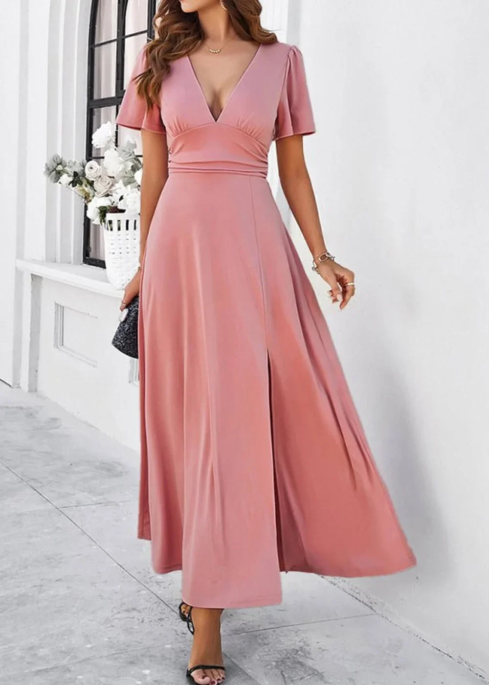 Pink flowy maxi dress with v-neck and thigh-high slit, on model.