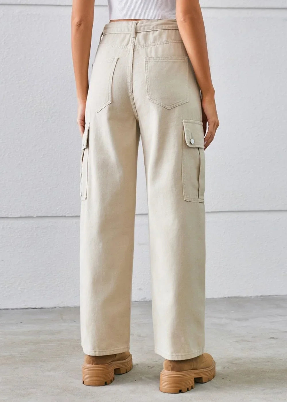Back view of light beige wide-leg cargo pants with button-flap pockets and tan platform boots.