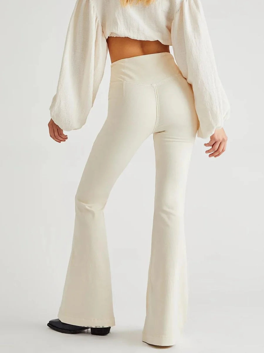 Cream flared pants with a v-shaped waist seam, shown from the back.