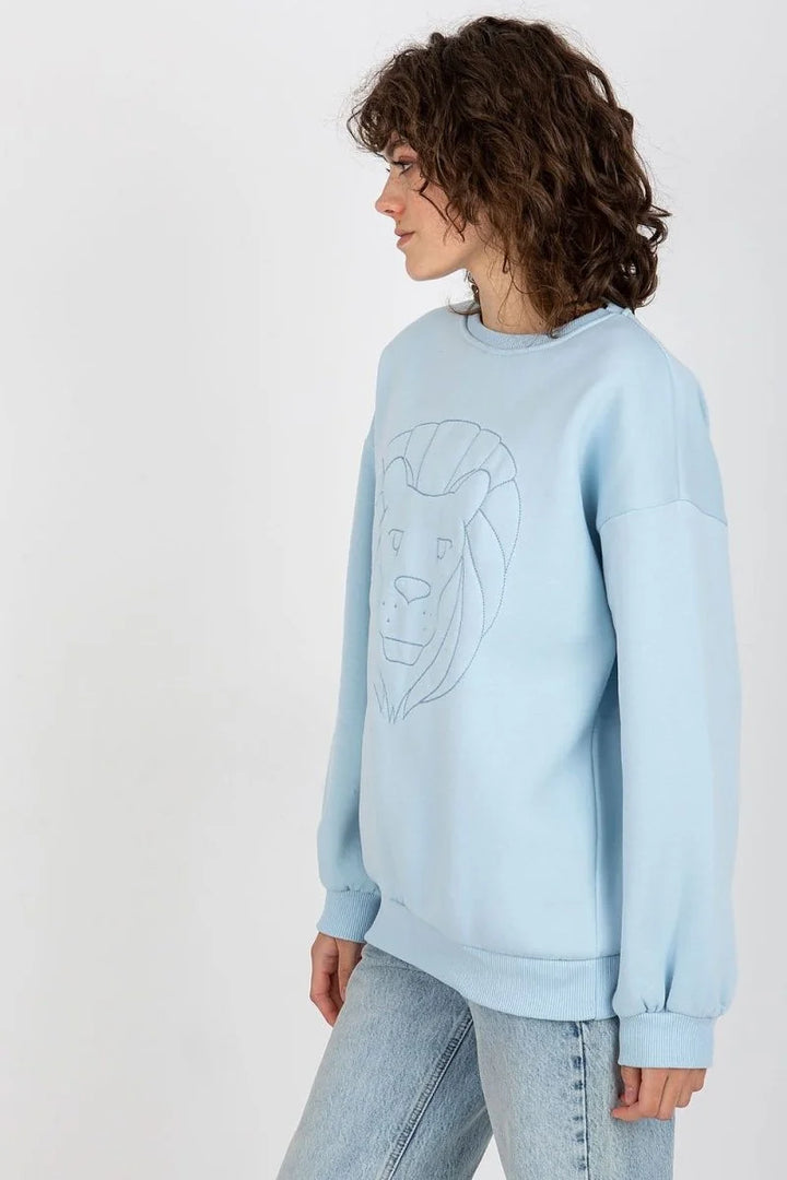 Light blue crewneck sweatshirt with embroidered lion graphic, relaxed fit.