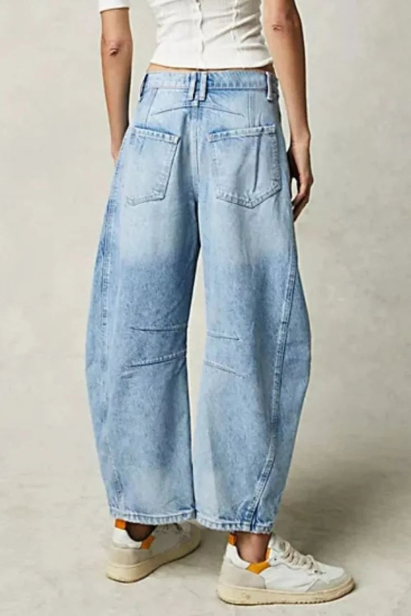 Light wash relaxed fit denim jeans with wide legs and visible stitching details.