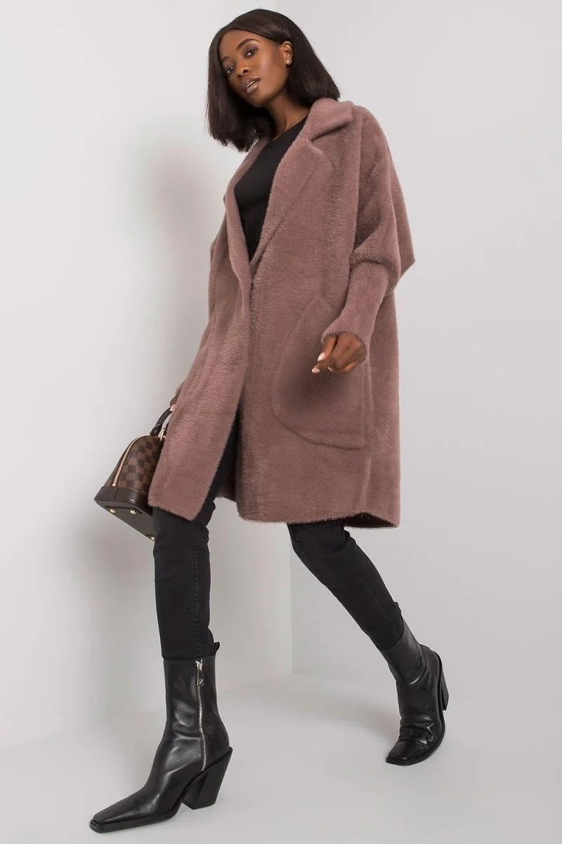 Woman in a plush, taupe, open-front cardigan with black skinny pants and black pointed-toe boots.