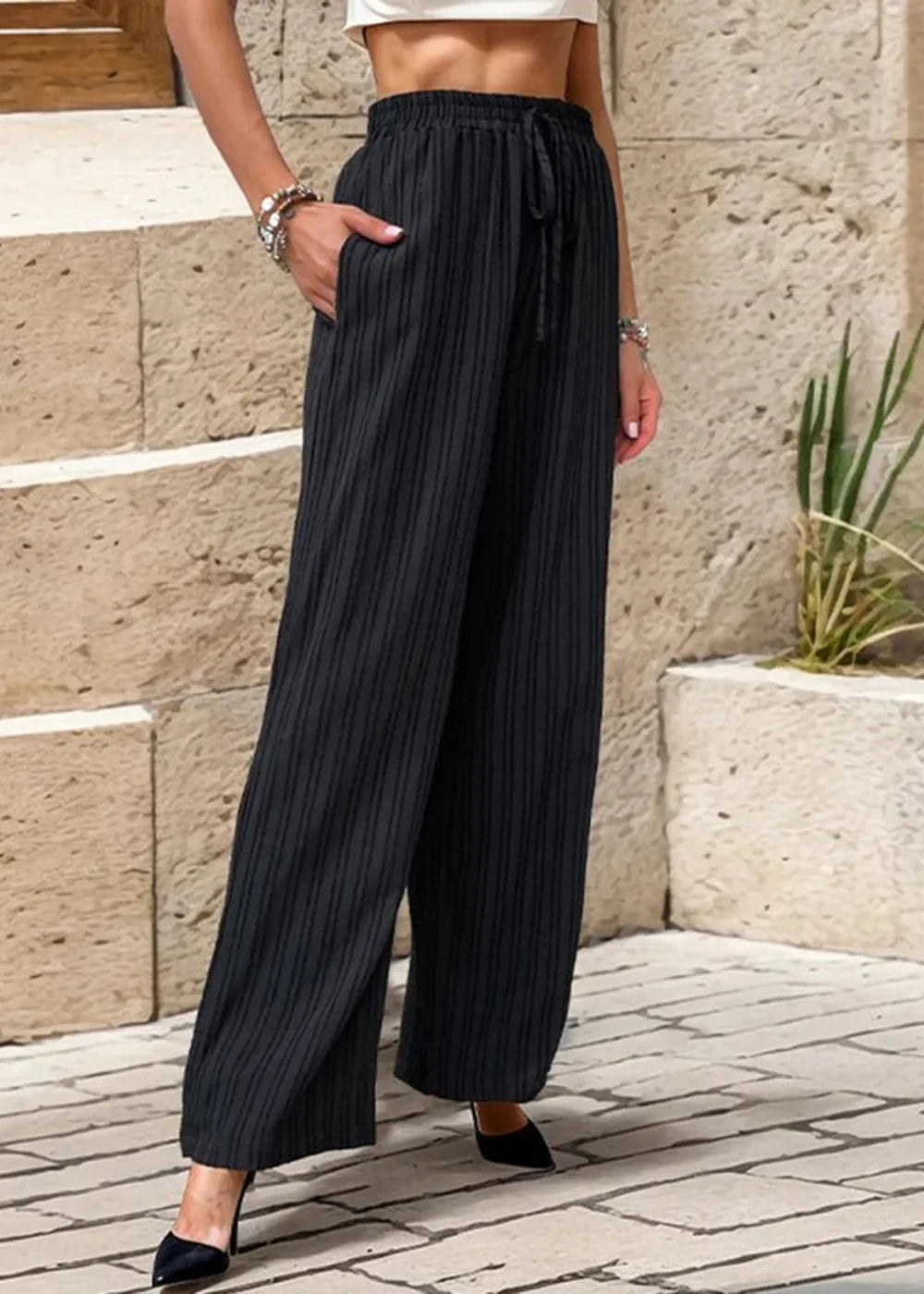 Black wide-leg pants with vertical pinstripes and a drawstring waist.