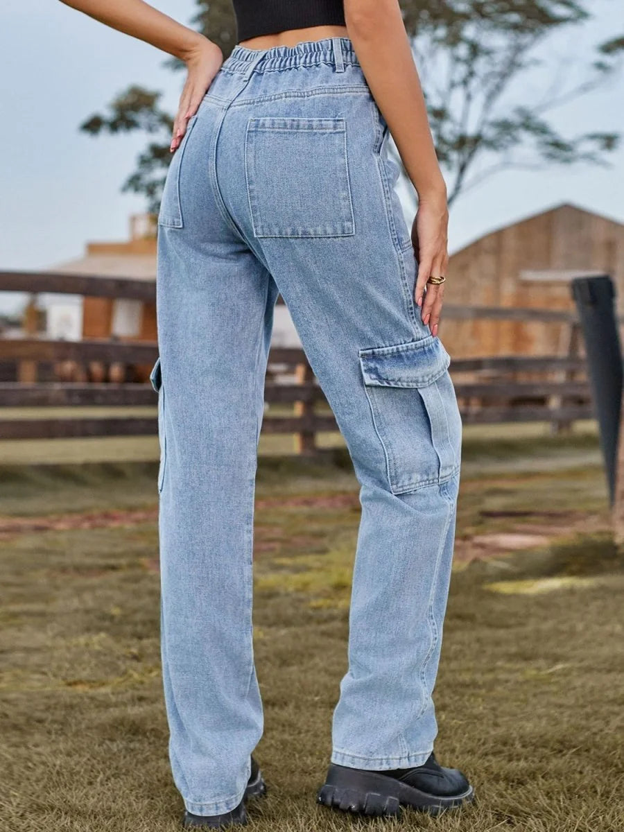 Light wash denim cargo pants with elastic waistband, side pockets, and wide legs.