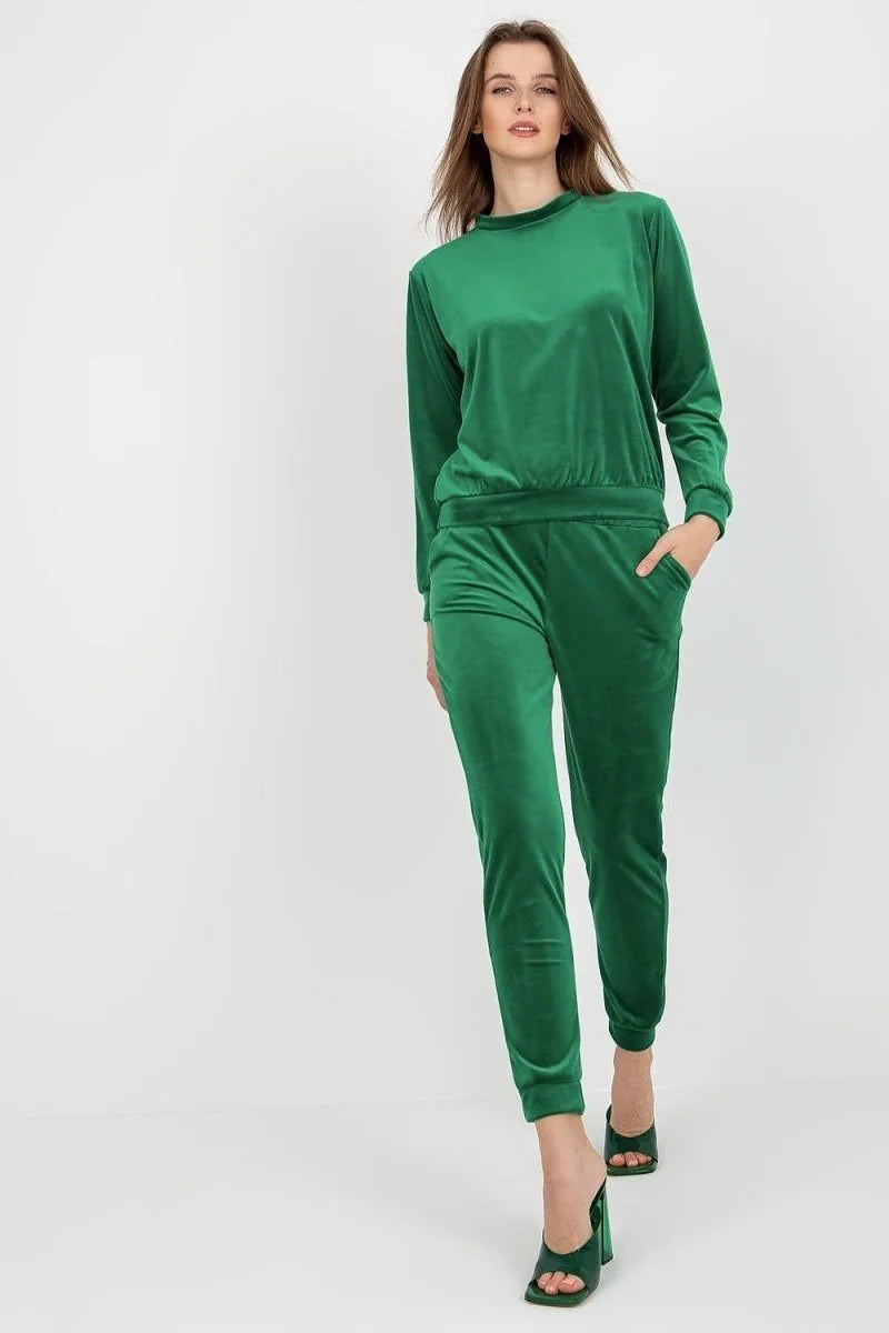 Emerald green velvet tracksuit with a relaxed fit, on a model wearing matching heels.