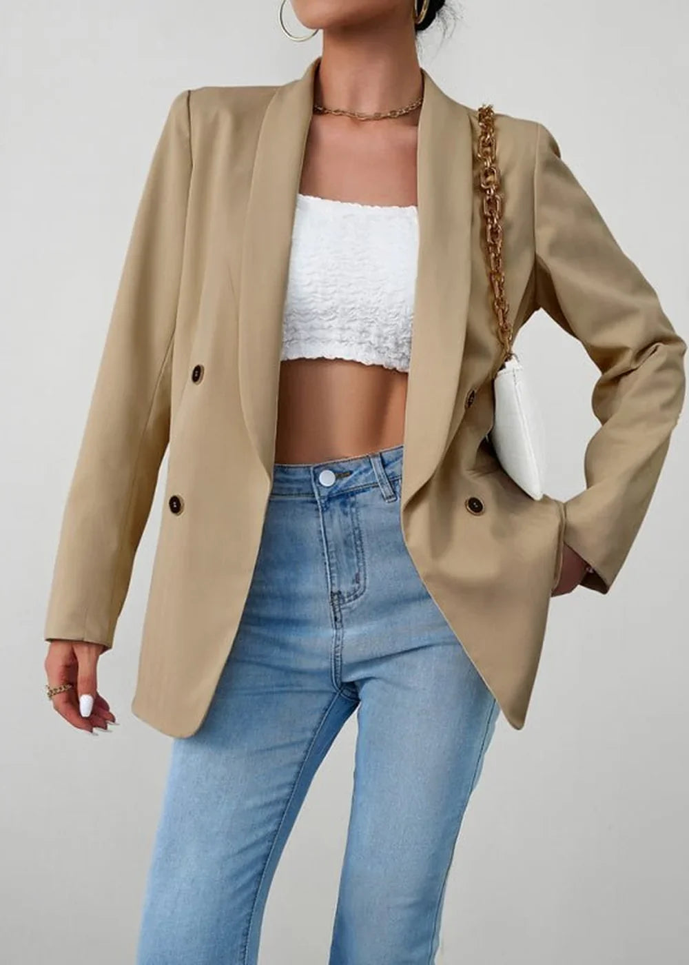 Tan double-breasted blazer with a white crop top and light wash jeans on a model.