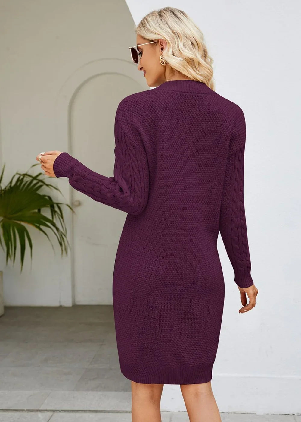 Women's wine cable knit sweater dress with long sleeves, shown from the back.