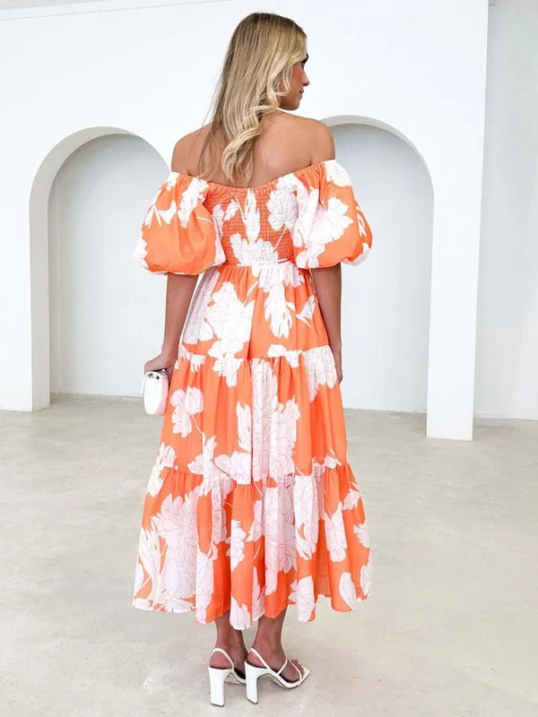Orange off-the-shoulder midi dress with white floral print, puffed sleeves, and tiered skirt.