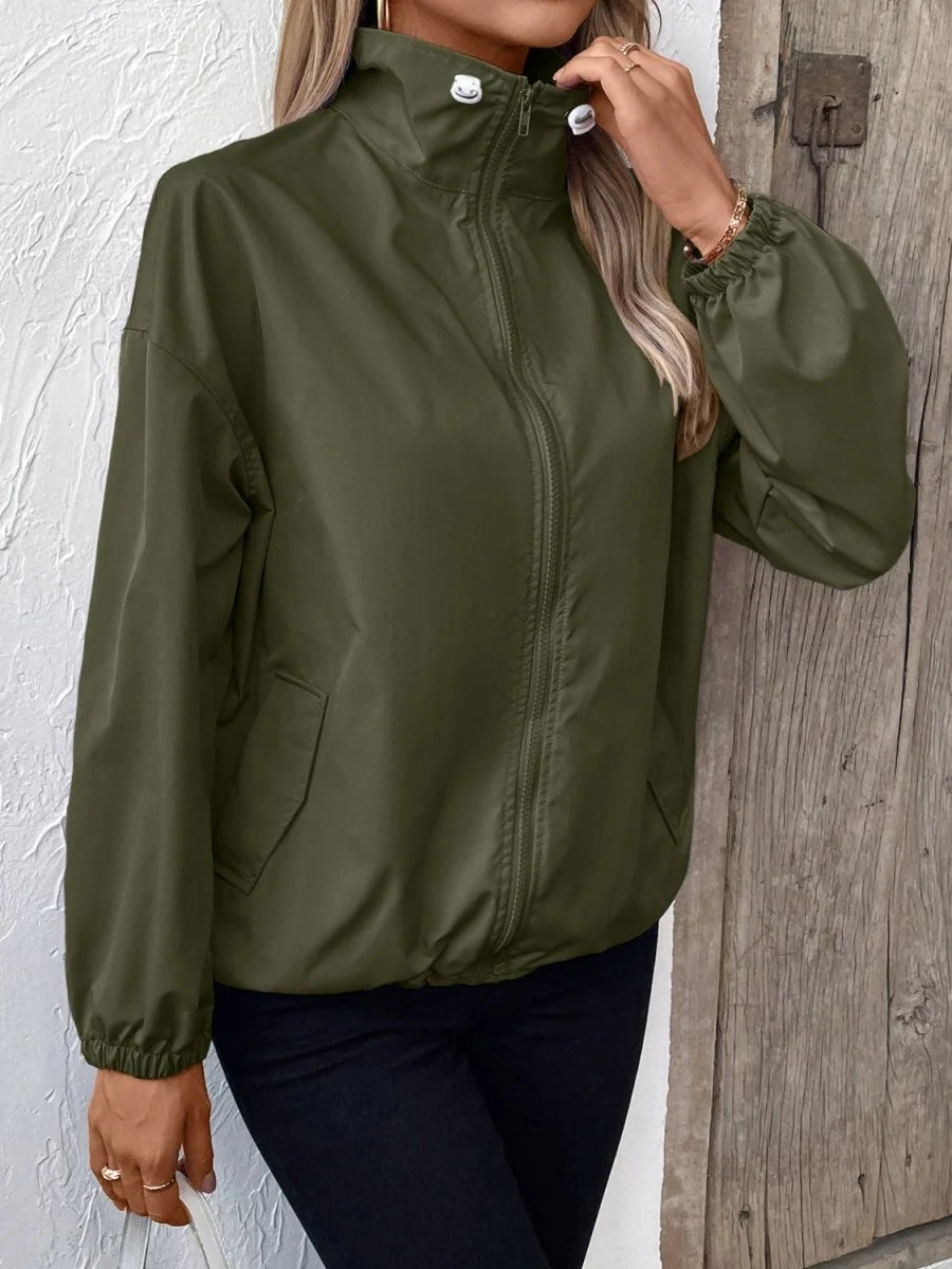 Olive green jacket with high collar, full zip, and gathered cuffs, worn by a model.