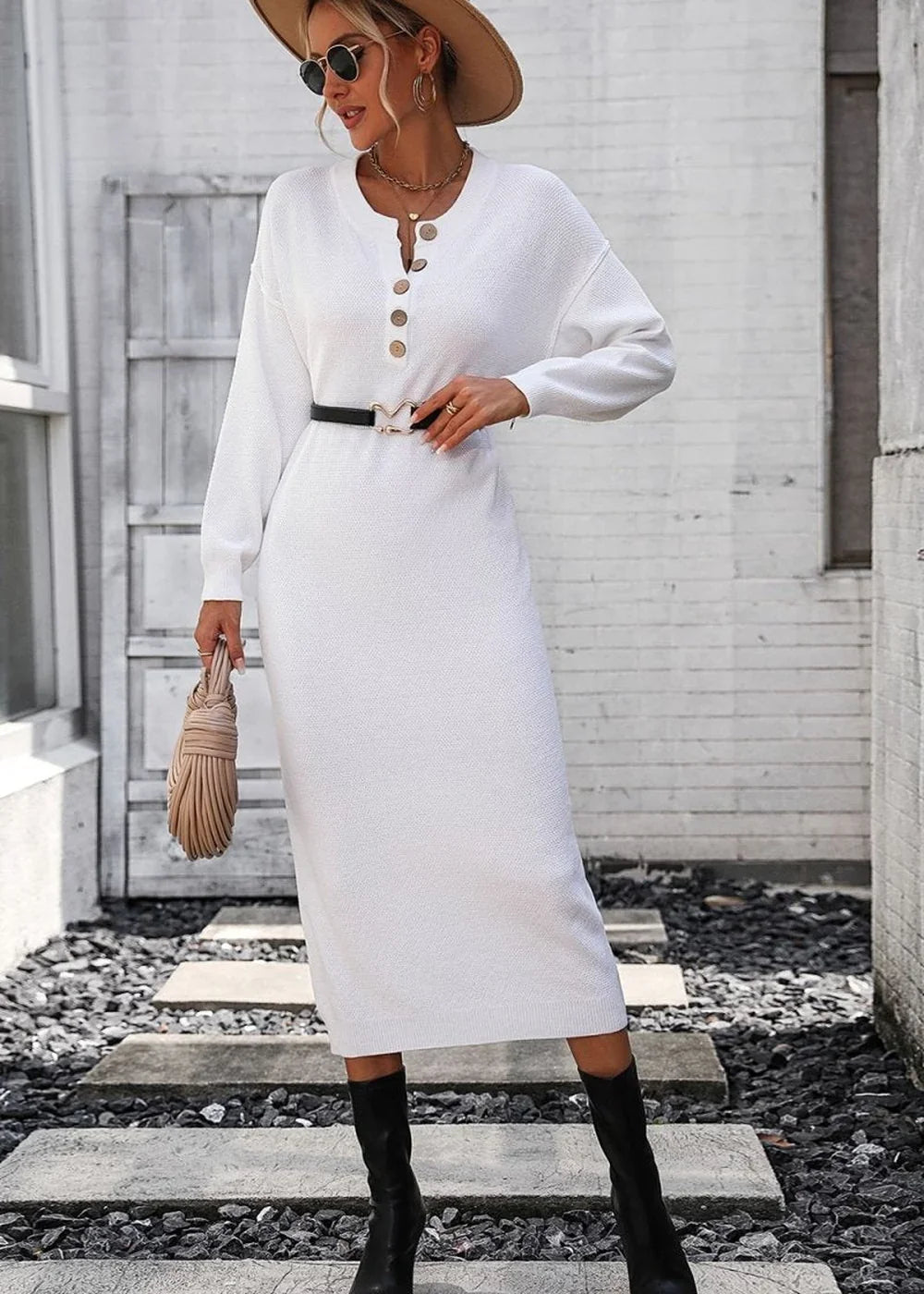 White knit midi sweater dress with gold buttons, black belt, and black boots on model.