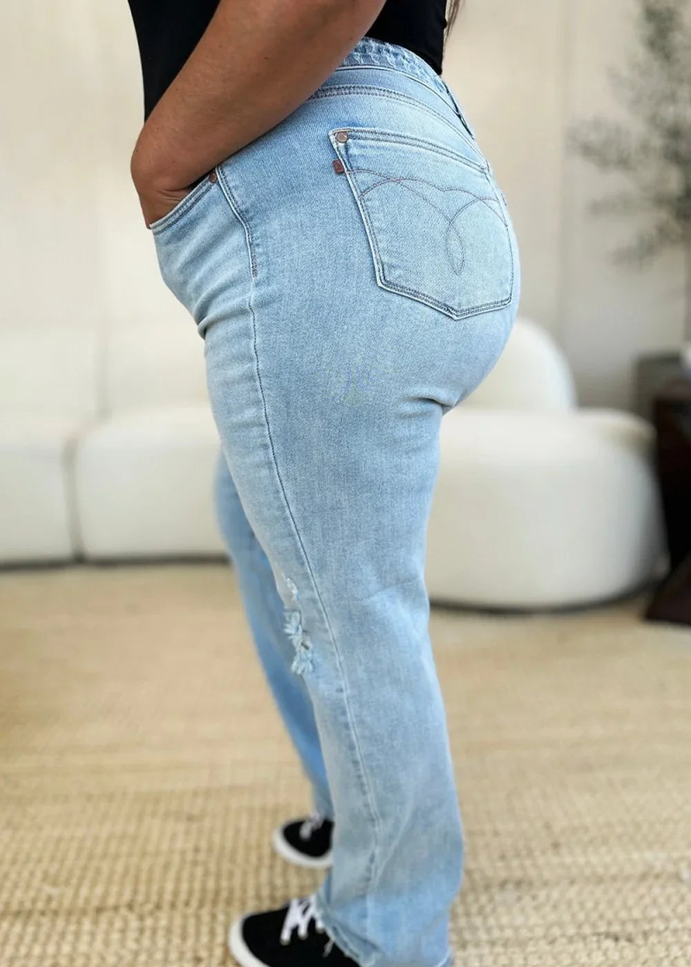 Light wash distressed denim jeans with a relaxed fit and frayed hem detail.