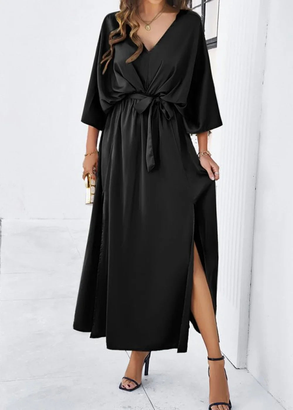 Black satin maxi dress with V-neck, cinched waist, and high thigh slit.