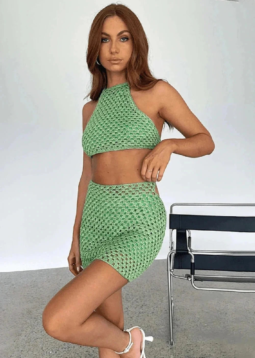 Green crochet halter top and mini skirt set with a textured pattern on a model.