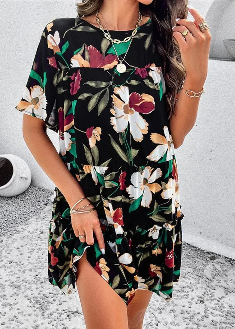 Black floral print dress with ruffled hem and short sleeves, worn by a model.