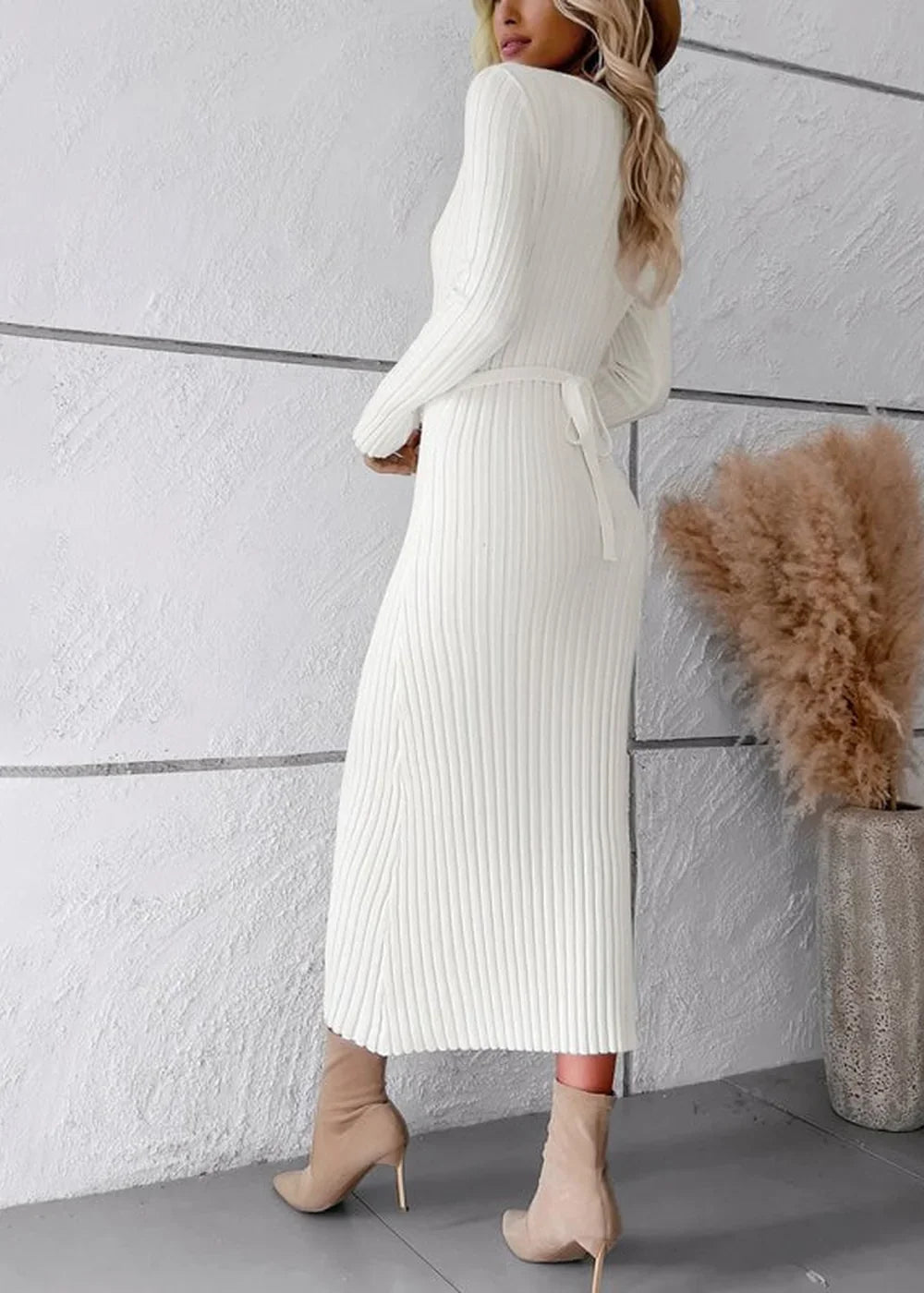 White ribbed knit sweater dress with a tie waist, worn by a model with tan heeled boots.