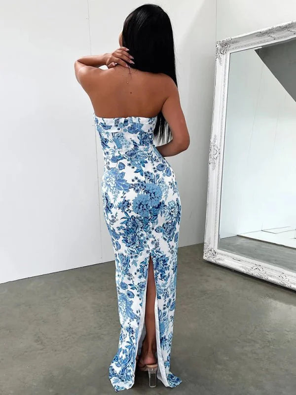 Strapless maxi dress with a blue floral pattern, featuring a thigh-high slit and clear heels.