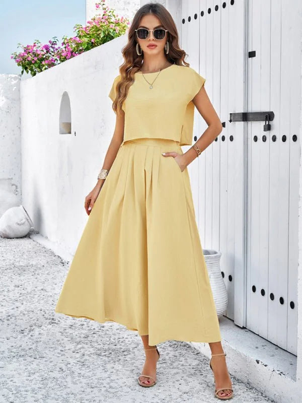 Pale yellow cropped top and pleated midi skirt set with pockets, on a woman.